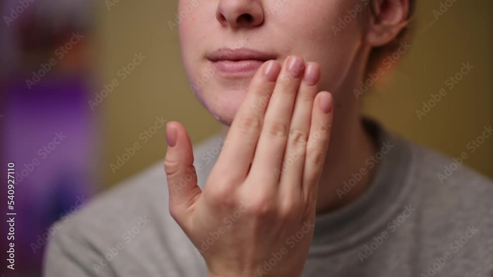 Close-up image of a woman applying skin care cream to her face. Healthy skin care concept Close-up image of a woman applying skin care cream to her face. Healthy skin care concept