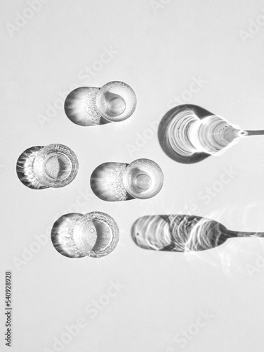 Vertical shot of champagne glasses casting a shadow in grayscale photo