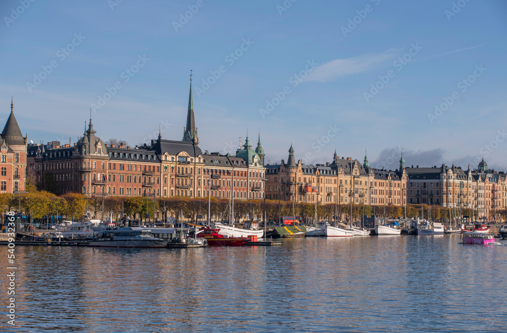 Panorama view, old fishing boats in the bay Ladugårdsviken with offices, apartment and hotel buildings a colorful autumn day in Stockholm