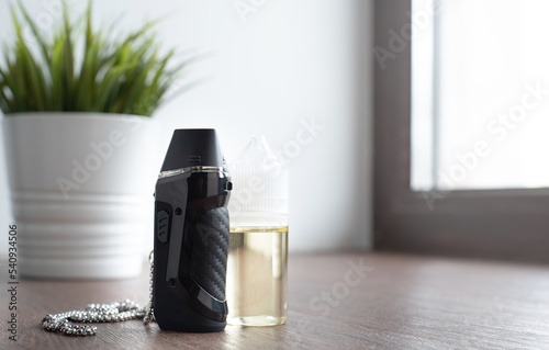 popuar vaping device with liquid on windowsill photo