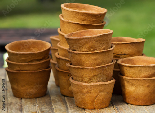 Heap of handmade clay pots on a wooden table