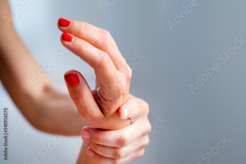 Detail of beautiful woman's hand with red nails receiving a massage but another woman. 