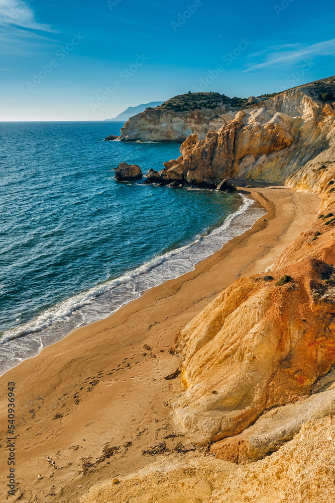 Sunset over beach, cliffs and hills and deep azure sea. Agios Ioannis