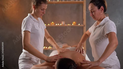 Relax tantric massage for woman in four hands using aromatherapy oils in spa. healthcare and female beauty.