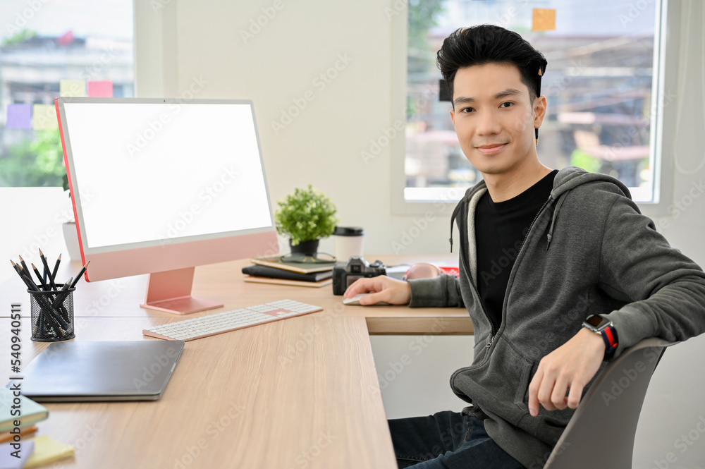 Handsome young Asian male office employee at his office desk