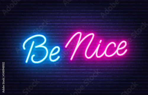 Be Nice neon quote on brick wall background.