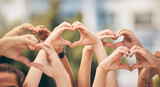 Hand, heart and love with a group of people making a sign with their hands outdoor together in the day. Crowd, freedom and community with man and woman friends doing a gesture to promote health