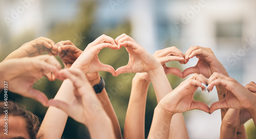 Hand, heart and love with a group of people making a sign with their hands outdoor together in the day. Crowd, freedom and community with man and woman friends doing a gesture to promote health