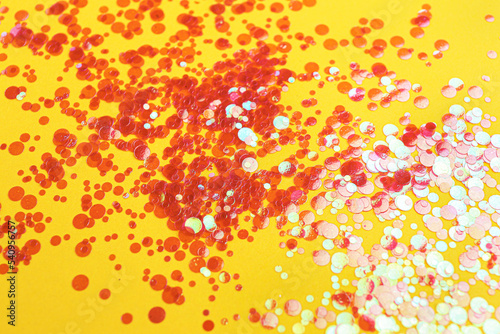 Shiny bright red glitter on yellow background