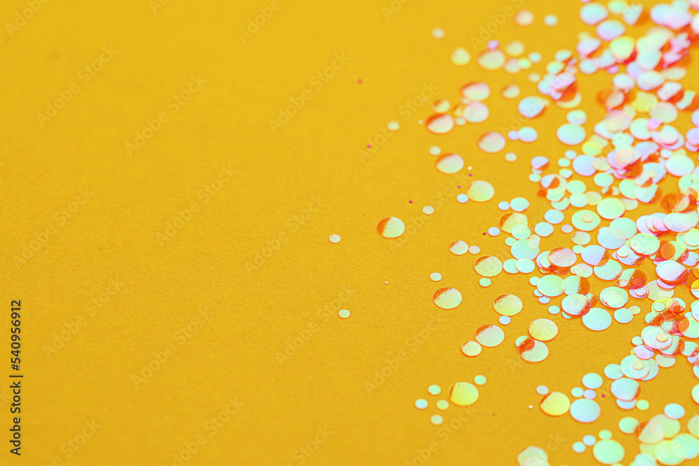 Shiny bright glitter on yellow background, closeup. Space for text