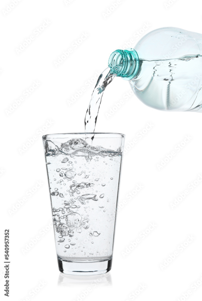 Pouring soda water from bottle into glass on white background