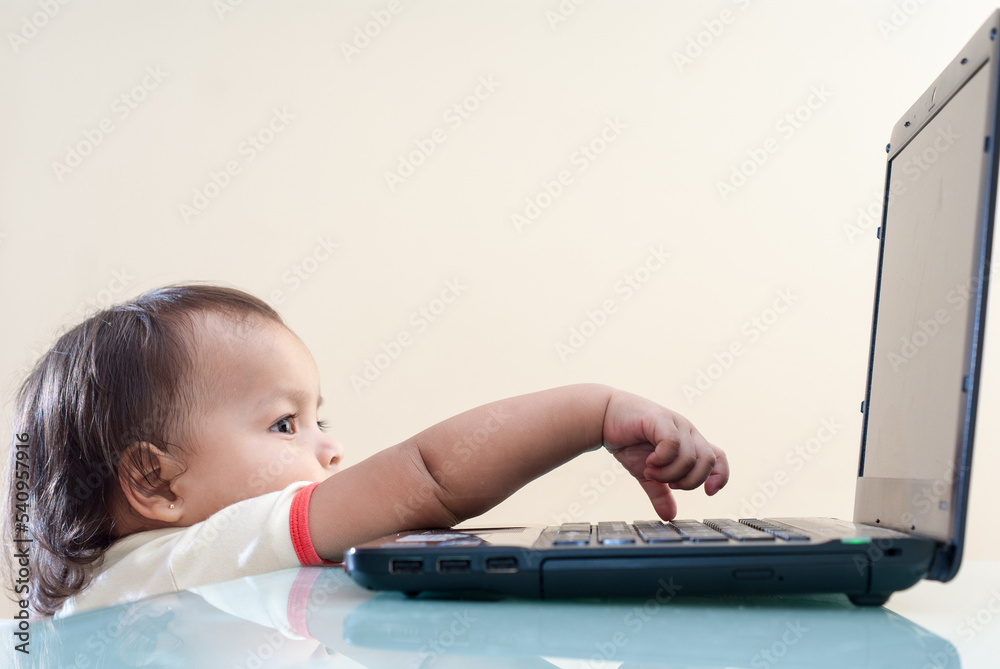 Cute baby computing. Little girl on a computer. Toddler using a