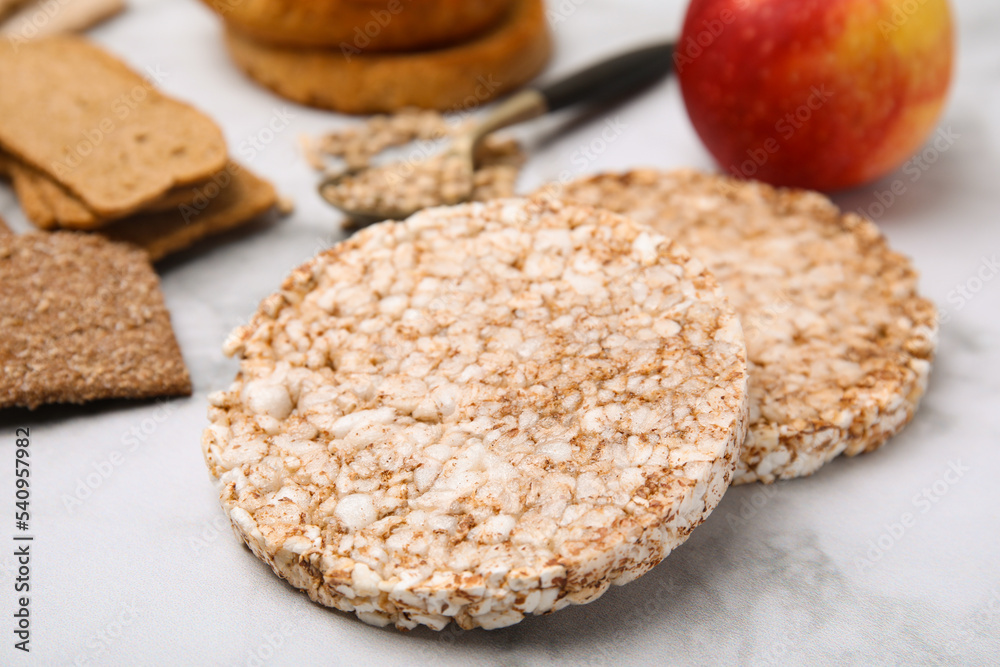Rice cakes and rusks on white marble table, closeup Rice cakes and rusks on white marble table, closeup