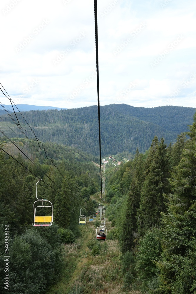 Ski lift and green trees at mountain resort