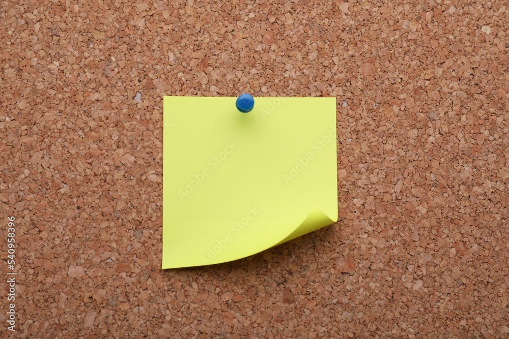 Blank paper note pinned to cork background, closeup Blank paper note pinned to cork background, closeup