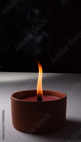 A burning candle isolated on a dark background. A candle with a flame in the dark close-up. A flame symbolizing the memory of the dead.