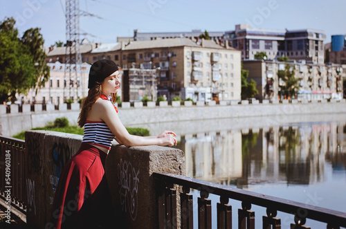 Fashion portrait of young, happy, elegant redhead curly woman, girl in hat and casual clothes. French style. Walking, relax in the city street. Sunny day.