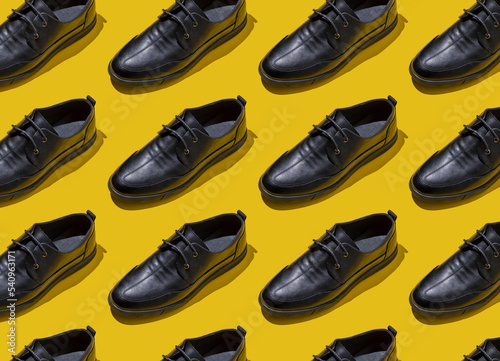 Shoe pattern. Black shoes on a yellow background top view with shadow. Accessories concept. New leather shoes. Classic office style. Men's fashion shoe. Flat minimalistic store advertising. Footwear