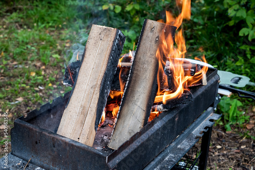 Fototapeta Naklejka Na Ścianę i Meble -  Firewood burning on Grill Open fire Close up Outdoor Barbecue Horizontal