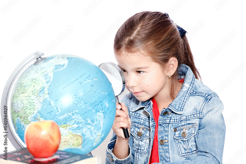 Curious little girl looking through magnifying glass on globe Curious little girl looking through magnifying glass on globe