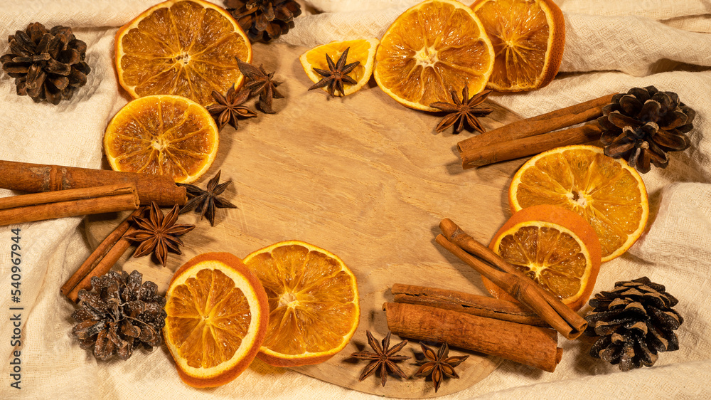 christmas winter food advent background - christmas scent, frame made of dried orange slices, cinnamon sticks and cloves, on rustic wooden table, top view christmas winter food advent background - christmas scent, frame made of dried orange slices, cinnamon sticks and cloves, on rustic wooden table, top view