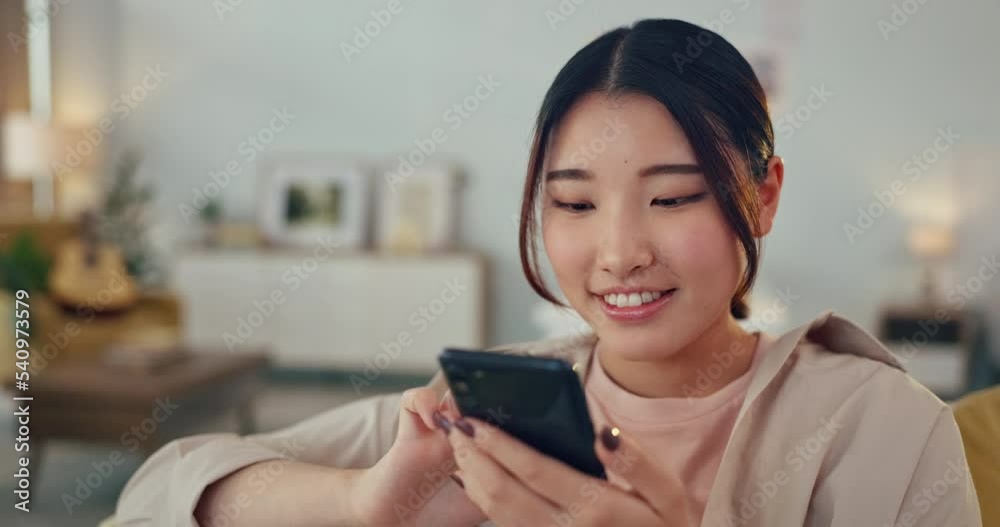 Asian woman, phone and social media with smile for communication relaxing on living room sofa at home. Happy Chinese female smiling for texting, chatting or browsing connection on mobile smartphone