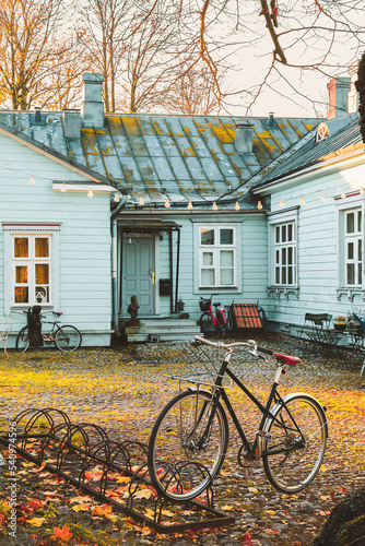 Helsinki, Finland - November 7, 2017: City bicycle parked in front of small house. Stone paved patio. Calm sunset scene at Suomenlinna. Selective focus.