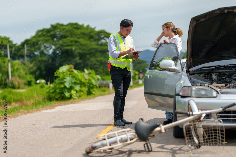 An insurance agent talking to a woman outside on the road after a car accident. An insurance agent talking to a woman outside on the road after a car accident.