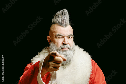 New Year and Christmas in the company of an unusual bad Santa. Evil aggressive gray-haired old man Santa in a bad mood. Severe dangerous Santa Claus with mohawk
