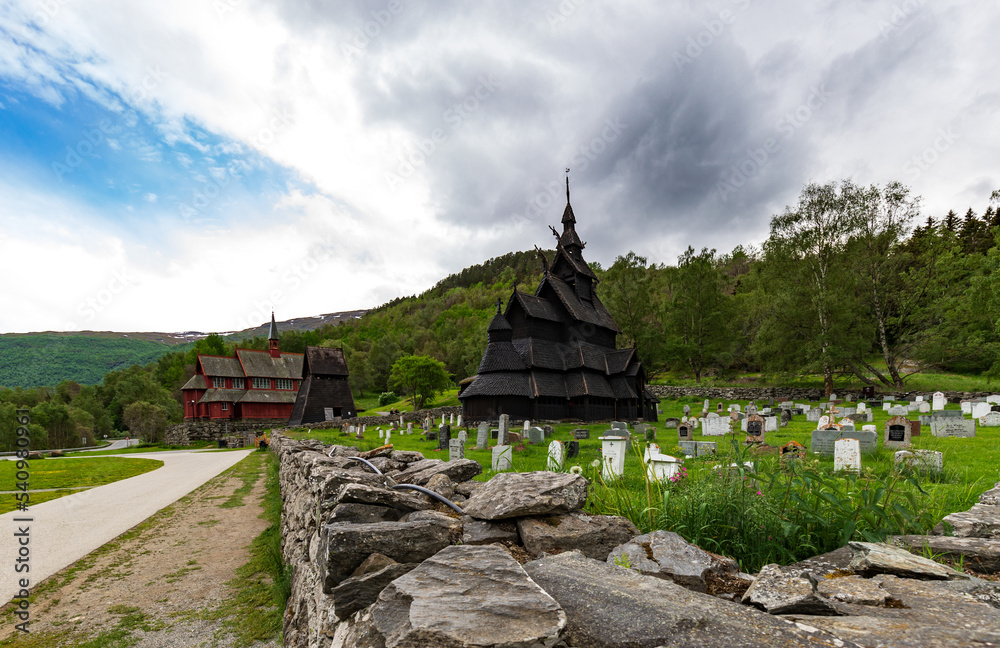 Former Parish Stave Church And Borgund New Church In The Summer Of June 2019 With Overcast Sky And Cemetery Foreground In Laerdal, Vestland Norway. Former Parish Stave Church And Borgund New Church In The Summer Of June 2019 With Overcast Sky And Cemetery Foreground In Laerdal, Vestland Norway.