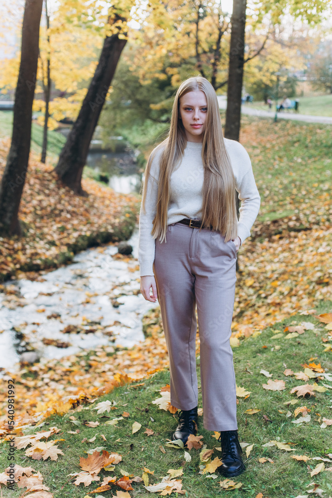 Close up blondie woman outdoor portrait in autumn park. Happy caucasian girl with long natural blondie hair Close up blondie woman outdoor portrait in autumn park. Happy caucasian girl with long natural blondie hair