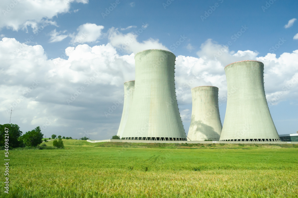 Nuclear power plant chimneys surrounded by green fields