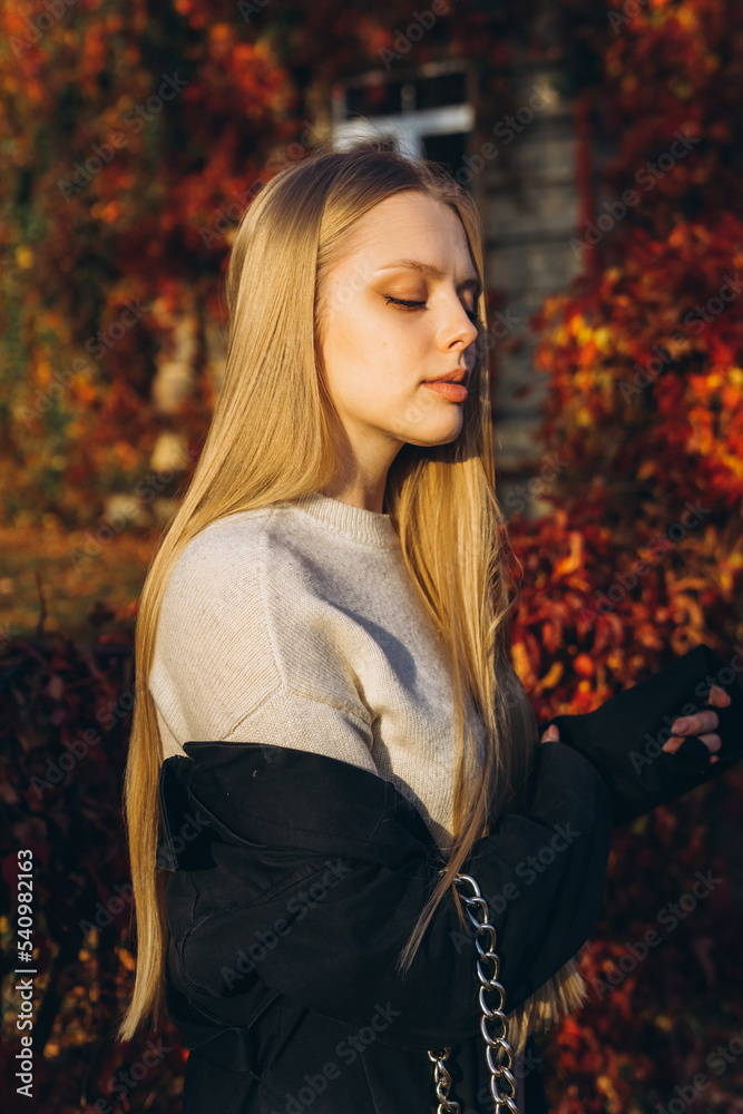 Close up blondie woman outdoor portrait in autumn park. Happy caucasian girl with long natural blondie hair Close up blondie woman outdoor portrait in autumn park. Happy caucasian girl with long natural blondie hair