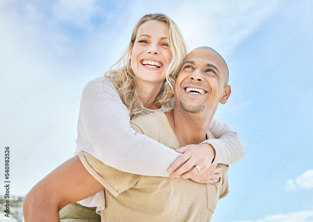 Woman, interracial couple and piggy back with love, happiness and fun in the sun outdoor. Happy people relationship with a smile in the sunshine together on travel and summer vacation with a blue sky Woman, interracial couple and piggy back with love, happiness and fun in the sun outdoor. Happy people relationship with a smile in the sunshine together on travel and summer vacation with a blue sky