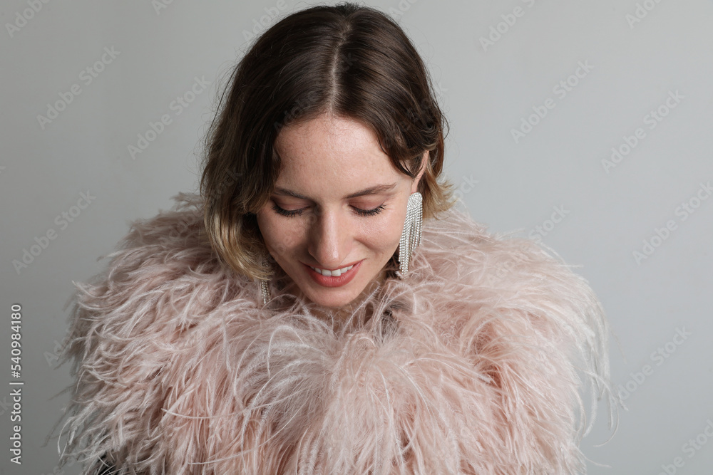 Happy elegant woman in stylish feathers dress posing in the studio. Mock-up. Happy elegant woman in stylish feathers dress posing in the studio. Mock-up.