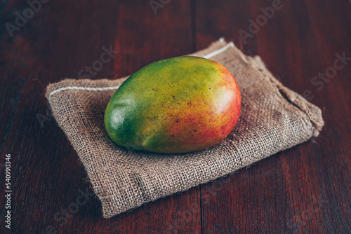 Mangue fraiche entière sur une toile de jute photo