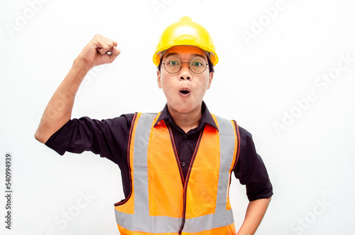 Happy ecstatic young Asian male construction worker, engineer, builder raising his fists doing yes gesture celebrating success. billboard model advertisment concept. 