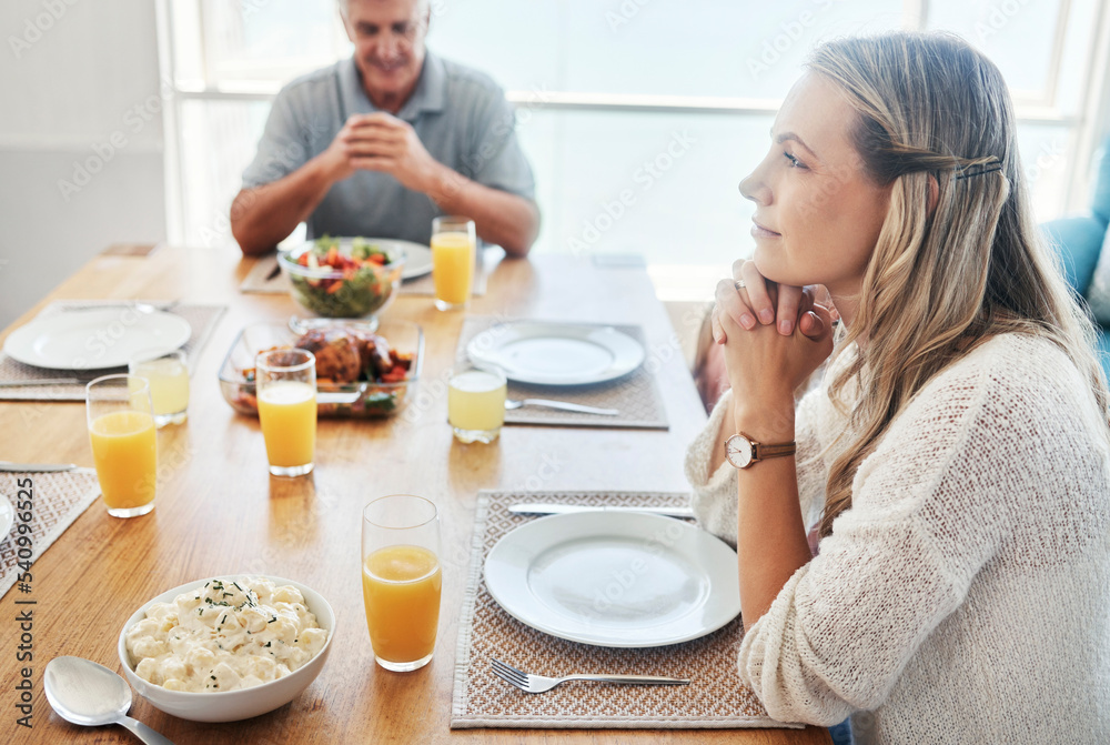 Woman, thinking at the dinner table in gratitude for food, family and home. Female sitting in thought with father in hope, spiritual and religion for grateful thanksgiving meal together