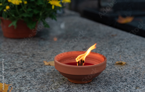 Burning candle on the tombstone. Flame symbolizing the memory of the dead. A candle with a large flame.