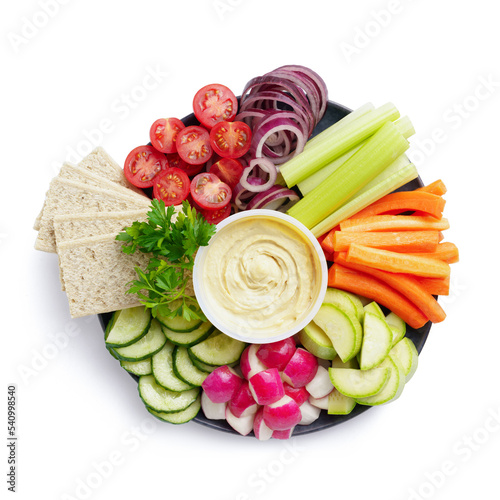 Healthy food plate with various raw vegetables, diet crispbreads and hummus, top view