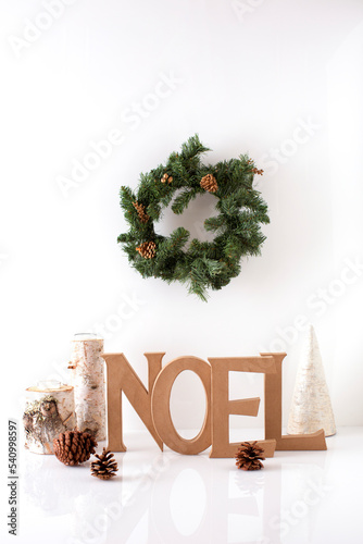 Text and decor on table with wreath hanging against white background photo