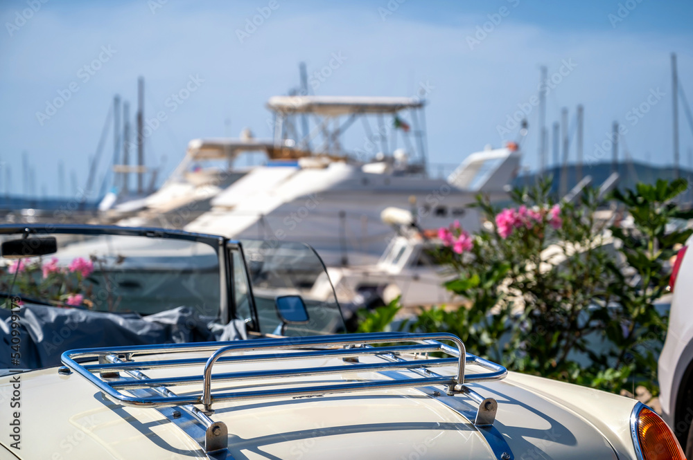 Oldtimer Cabrio am Hafen von Alghero auf Sardinien mit Yachten im Hintergrund