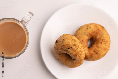 plate of methu vadai with cup of tea on table. photo