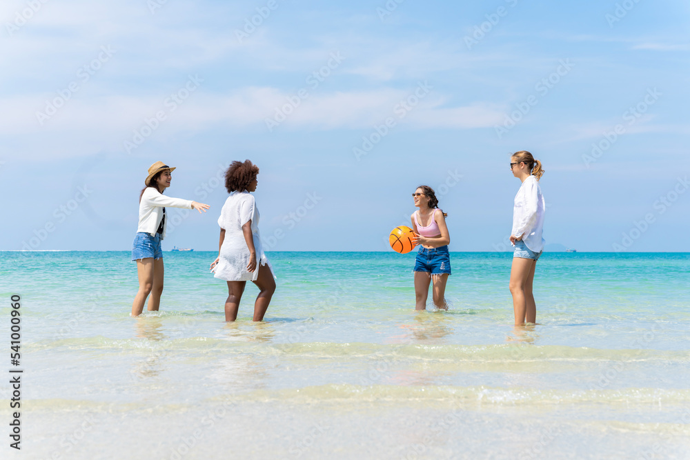 Photo of a group of girls of different ethnicities running and having fun together at the beach. on a fresh day