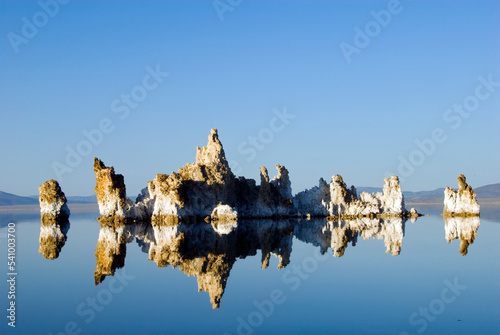 Large tufa formations are illuminated and reflected in afternoon light in Mono Lake, CA. photo