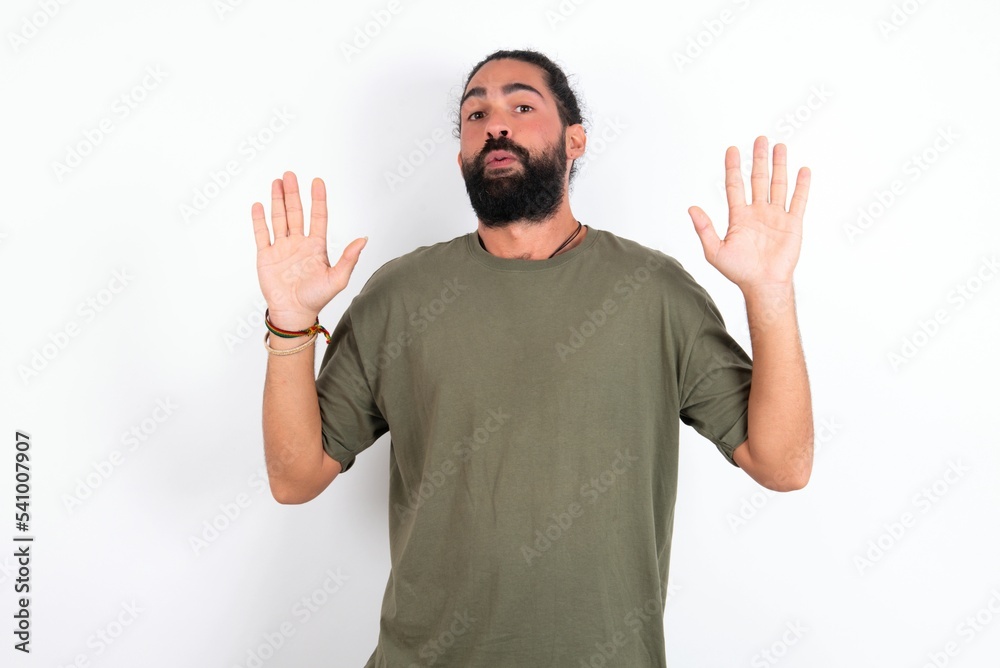 young bearded hispanic man wearing green t-shirt over white background Moving away hands palms showing refusal and denial with afraid and disgusting expression. Stop and forbidden. young bearded hispanic man wearing green t-shirt over white background Moving away hands palms showing refusal and denial with afraid and disgusting expression. Stop and forbidden.
