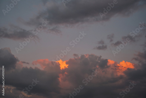 Dramatic clouds lit by the sun on a dramatic sunset sky. Selective focus on clouds, background or weather news idea.