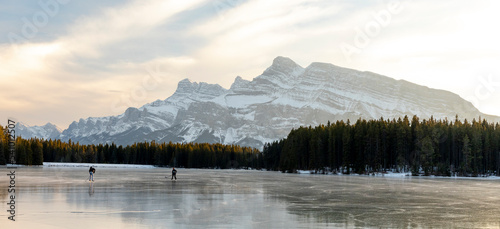 People ice skating on frozen Two Jack Lake, Alberta, Canada