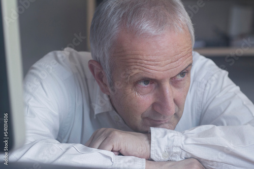 Close-up of a senior businessman sitting in the office and thinking, Freiburg im Breisgau, Baden-Württemberg, Germany