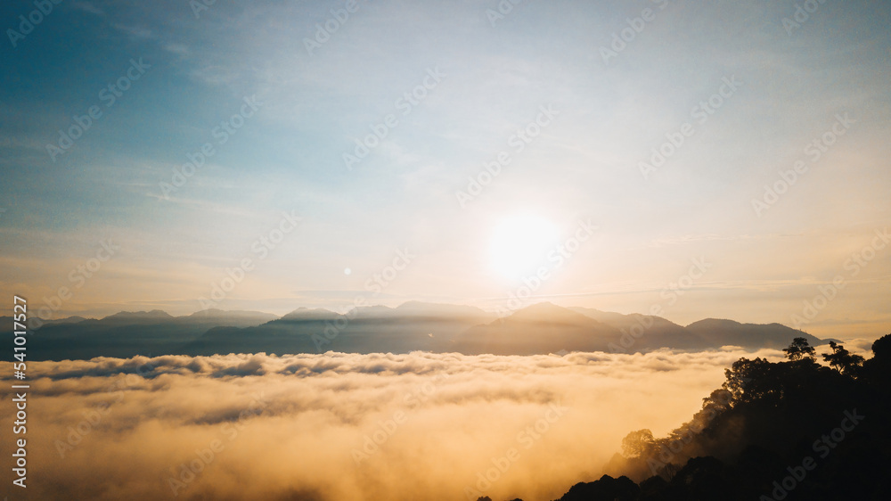 Fototapeta premium Sea clouds during golden sunrise above the Titiwangsa range mountains in Lenggong, Perak.